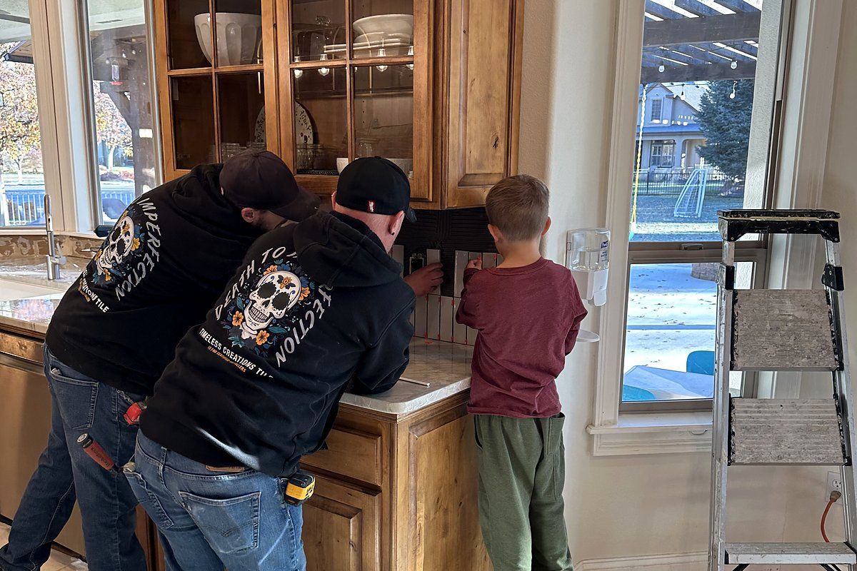 Setting a backsplash with a young helper