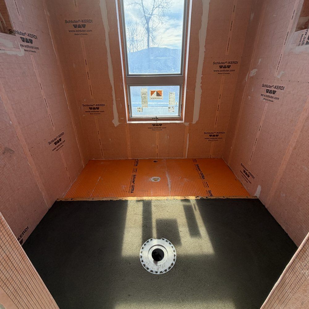 Shower ready for tile: Kerdi-board walls, Ditra on the floor, and a sloped mortar pan with the drain set